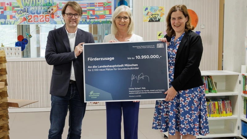 Bayerns Familienministerin Ulrike Scharf (Mitte) bei der Förderscheckübergabe an die Landeshauptstadt München zusammen mit Stadtschulrat Florian Kraus und Münchens Dritter Bürgermeisterin Verena Dietl. (Foto: StMAS / Schäffler)