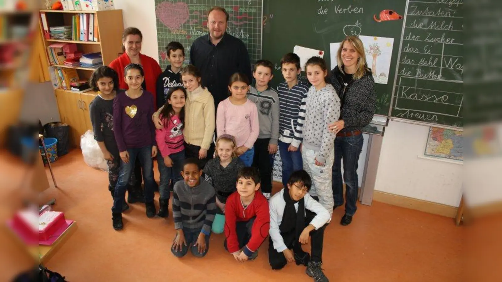 Christian Dörr von Hafis e.V. zusammen mit Eva Wobido (l.), Rektorin der Grundschule am Winthirplatz, Klassenlehrerin Katrin Richter (r.) und Kindern aus der Übergangsklasse, die an der Winthirgrundschule WIN-Klassen heißen. (Foto: sb)