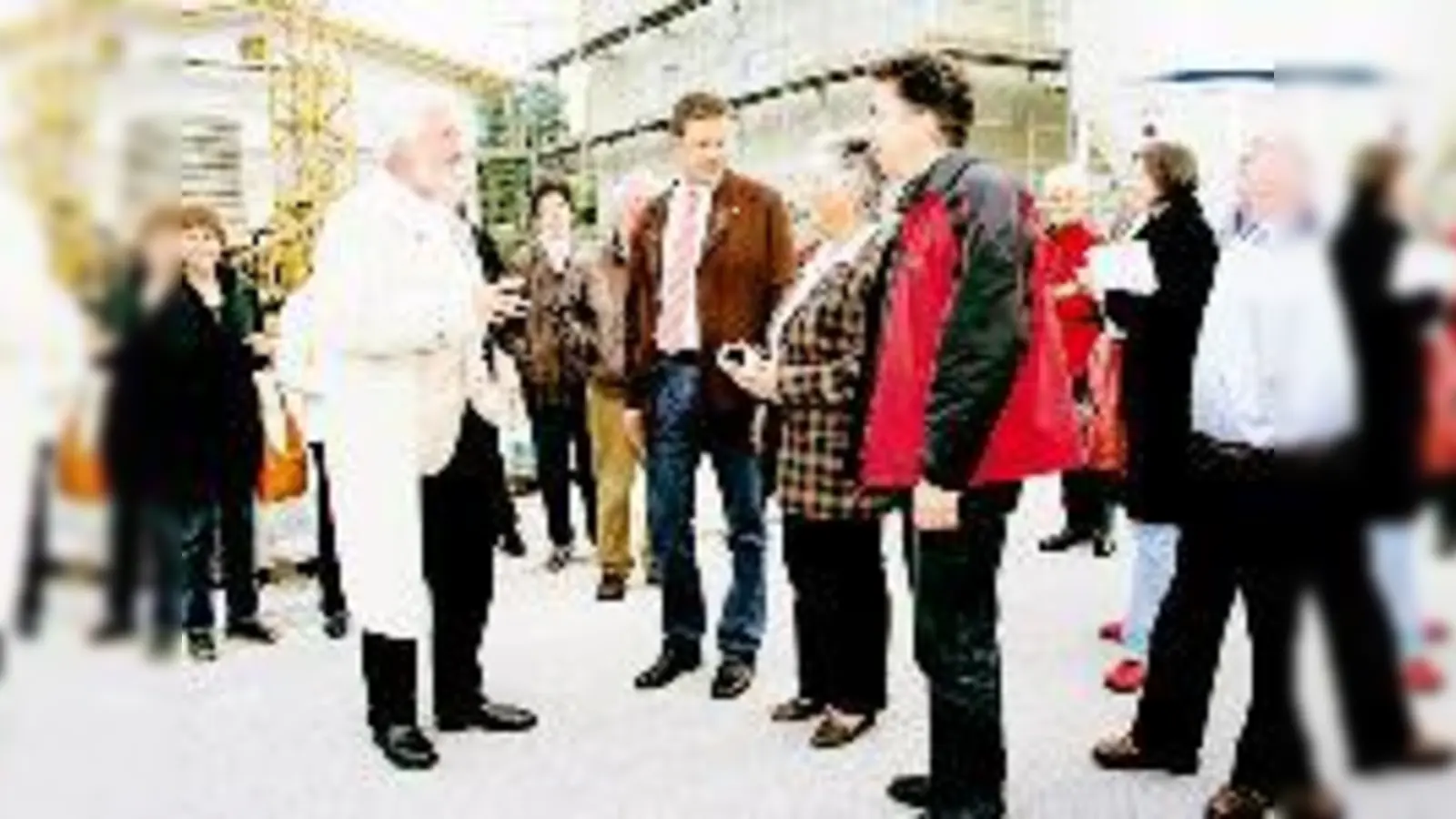 Der Vorstandsvorsitzende der Diakonie Rosenheim, Peter Selensky (im hellen Mantel), informiert SPD-Politiker und interessierte Bürger über die an der Waldbahn entstehenden Sozialwohnungen.   (Foto: esm)