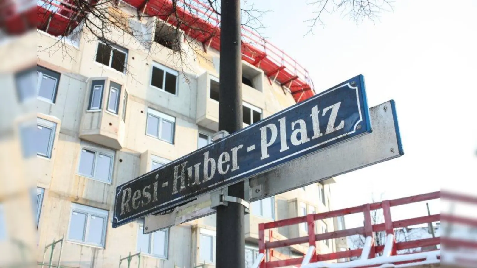 Das Straßenschild am Resi-Huber-Platz bekommt eine knappe Zusatztafel. Dahinter entsteht das Studentenwohnheim. (Foto: job)