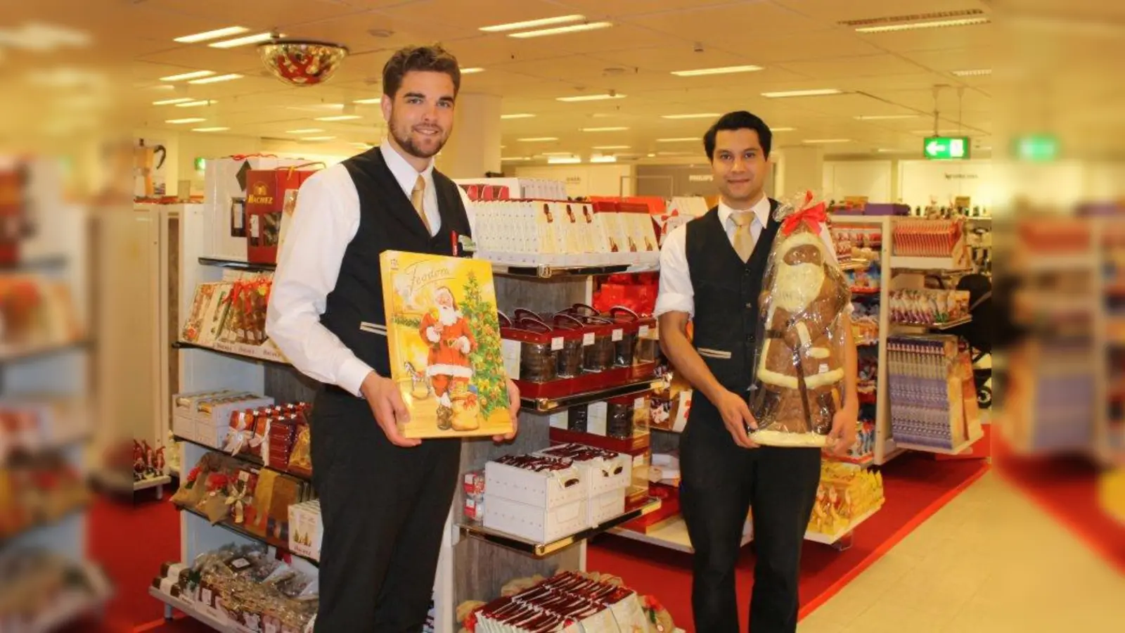 Umberto Englmann (l.), stellvertretender Leiter der Gourmetabteilung, und Alexander Pollok, Leiter der Süßwarenabteilung, freuen sich auf die Eröffnung des Weihnachtsmarktes in der Galeria Kaufhof am Rotkreuzplatz. (Foto: sb)