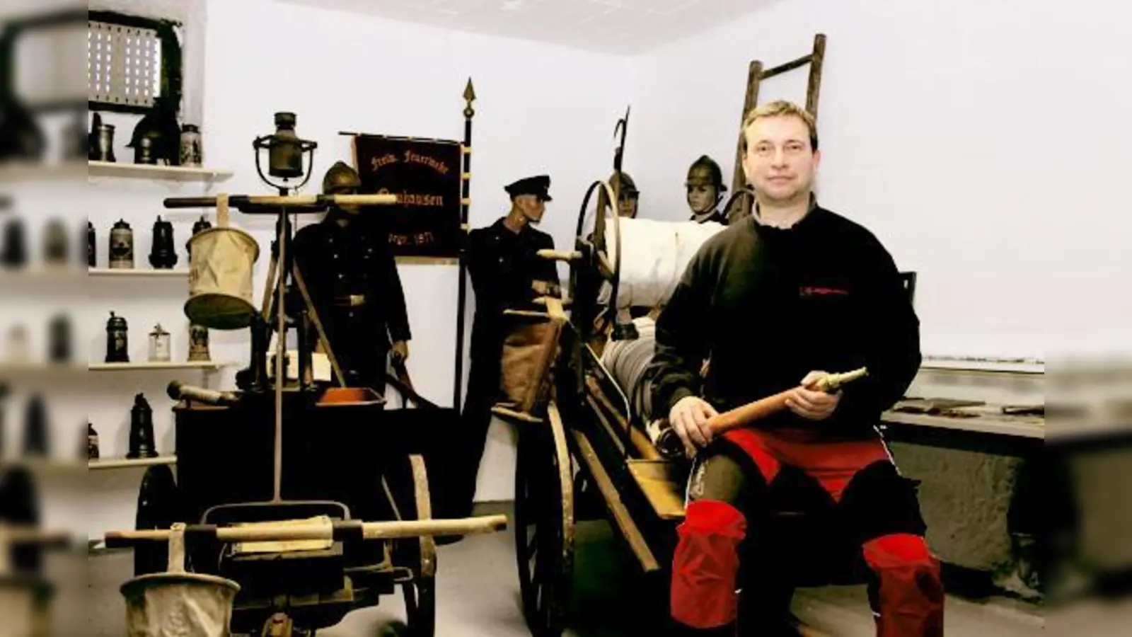 Münchner Feuerwehrgeschichte zum Anfassen: Andreas Abend sitzt in seinem Museum auf einem Hydrantenwagen, den um 1910 die FFW Neuhausen nutzte.  (Foto: bs)