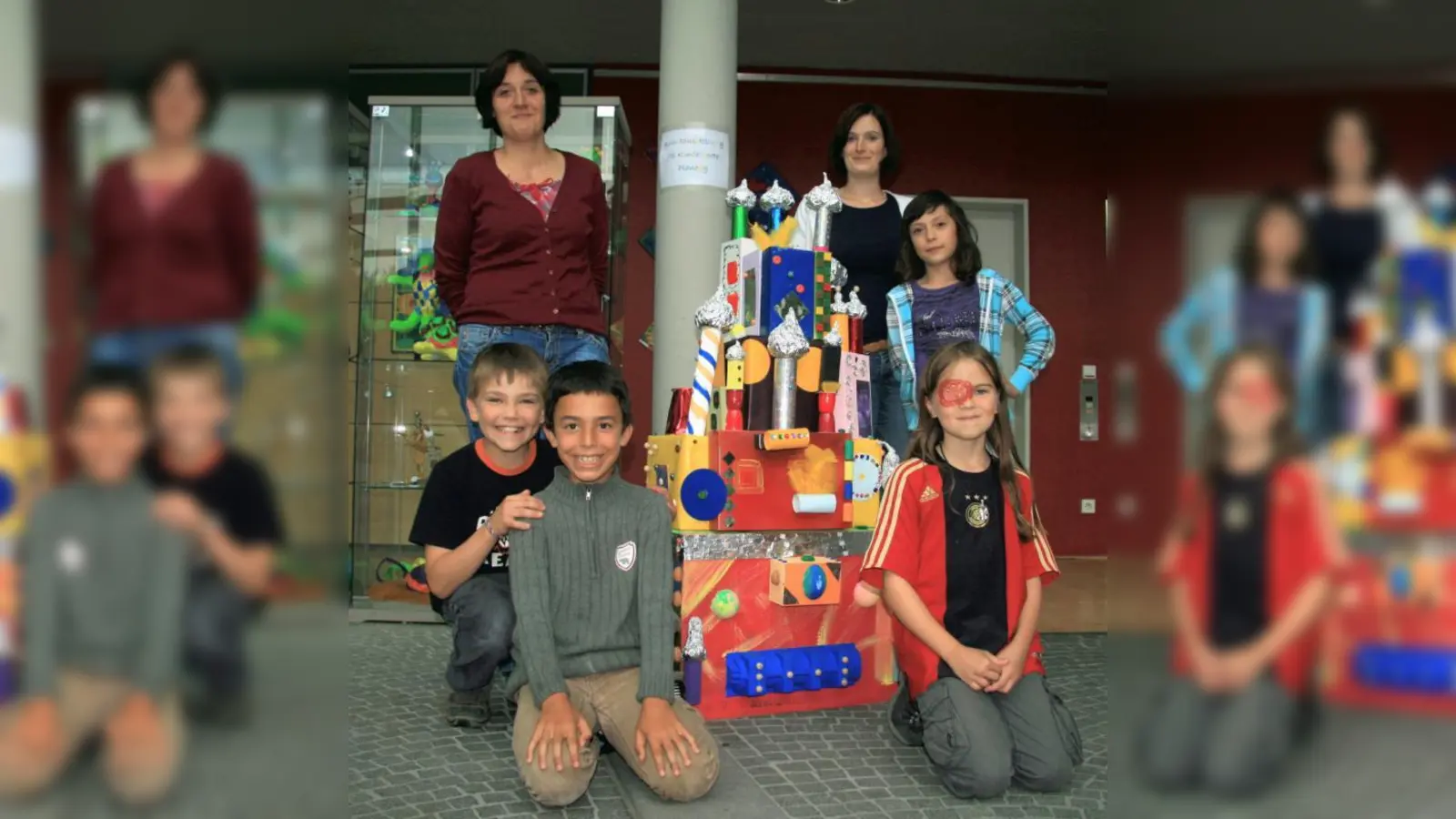 Hortleiterin Heidi Fina und Katrin Ehlert (v.l.) mit den Hortkindern Ole, Murad, Laura und Miriam vor dem Hundertwasser-Haus. Drei Wochen lang sind die Kunstwerke im Rathaus ausgestellt. (Foto: US)