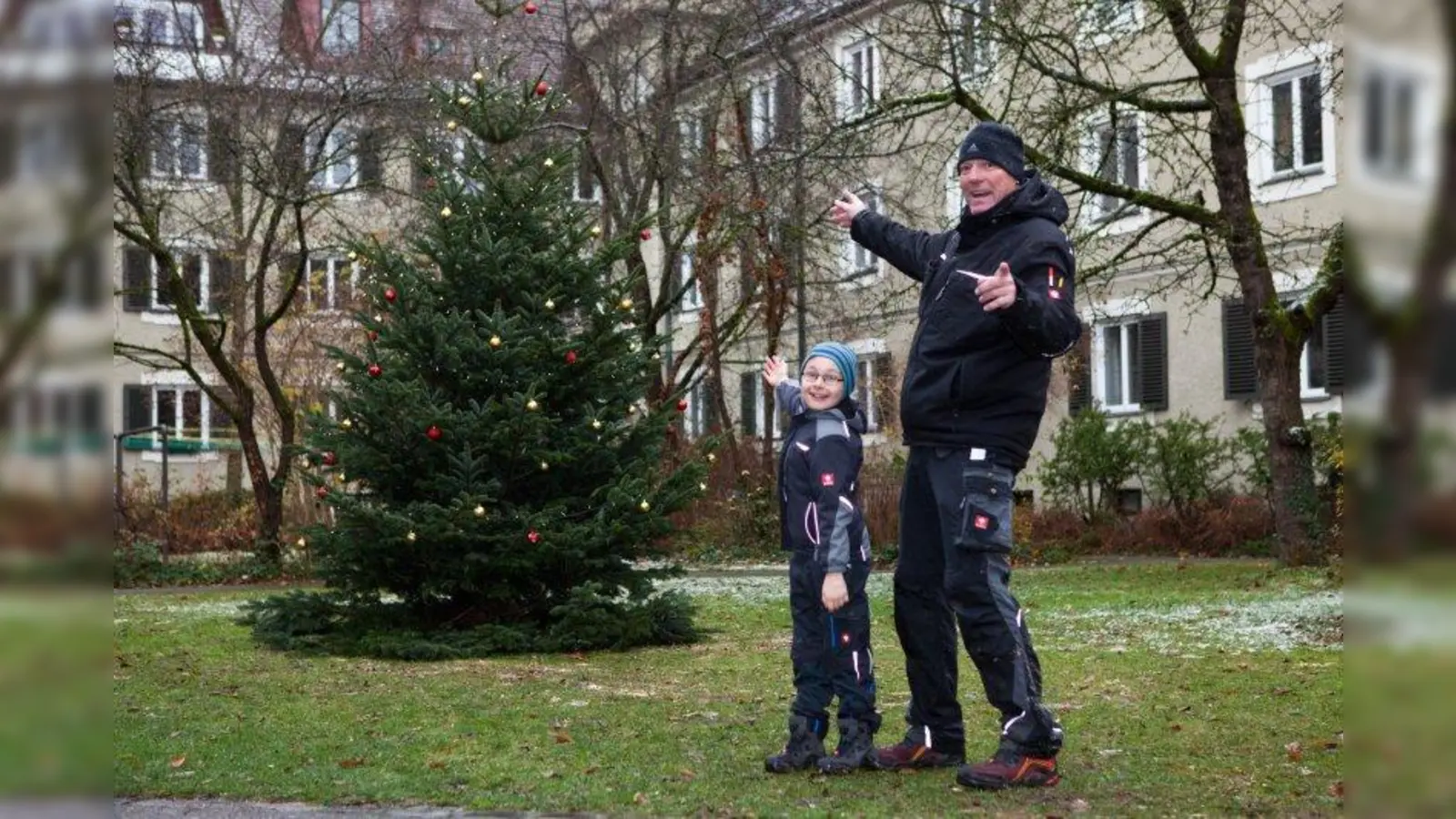 Er steht und erstrahlt im Lichterglanz: Hausmeister Georg Seidenschwang und der 9-jährige Constantin Wedlich präsentieren den Weihnachtsbaum. (Foto: privat)
