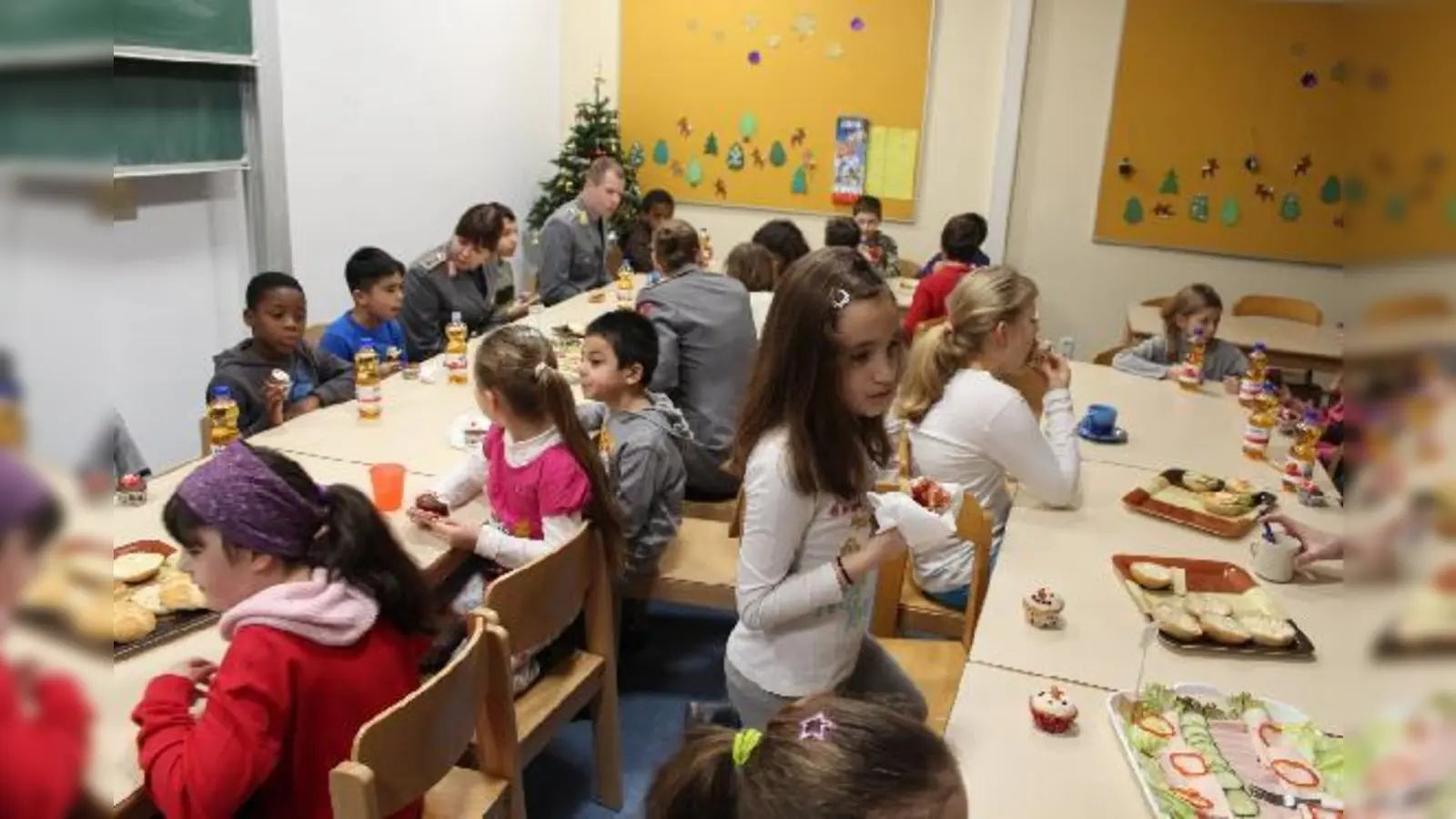 Die Frühstücksklub-Kinder mit den Soldatinnen und Soldaten beim Frühstück in der Grundschule an der Ittlingerstraße.	 (Foto: Deutsche Lebensbrücke)