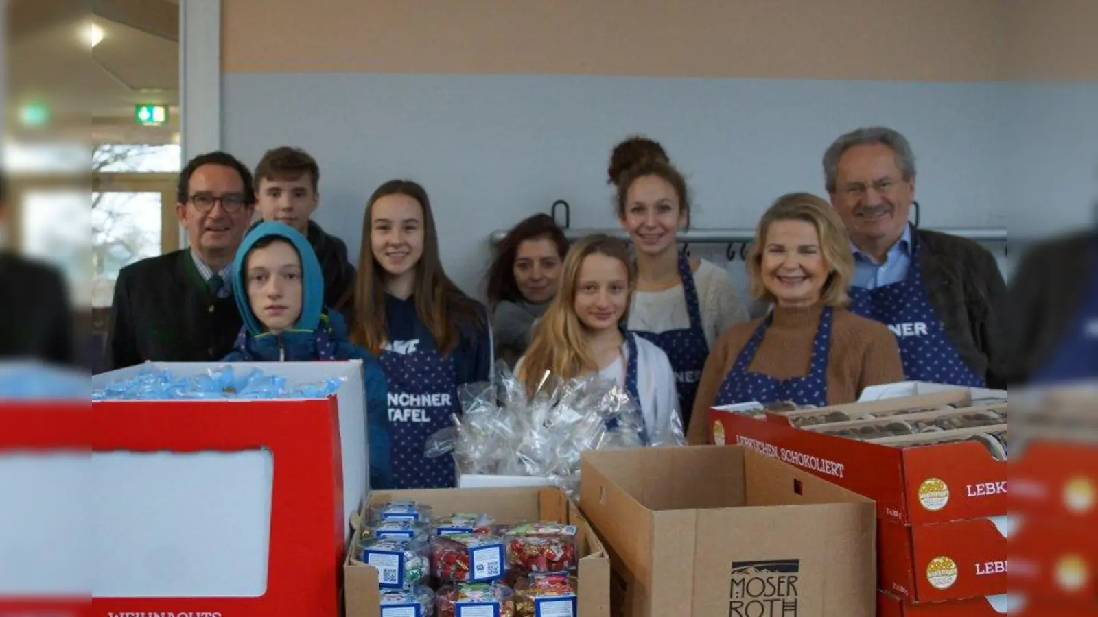 Weihnachtsaktion: Tafel-Vorstand Matthias von Miller (links), Stiftungsgründerin Eva-Sophie Koch (Mitte), Margitta Schmitt (2. von rechts, Kuratoriumsmitglied der Koch-Ebersperger-Stiftung) und Alt-OB Christian Ude (rechts) zusammen mit Schülern des Käthe-Kollwitz-Gymnasiums. (Foto: Koch-Ebersperger-Stiftung)