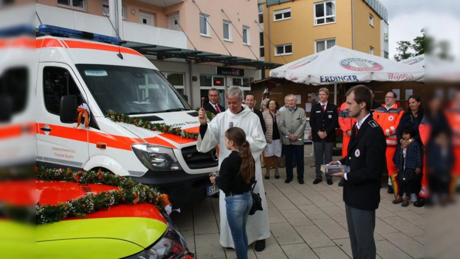 Kirchlicher Segen: Pfarrer Franz von Lüninck weihte das neue Helfer-vor-Ort-Fahrzeug und einen Krankentransportwagen des BRK Gilching. (Foto: BRK Gilching)