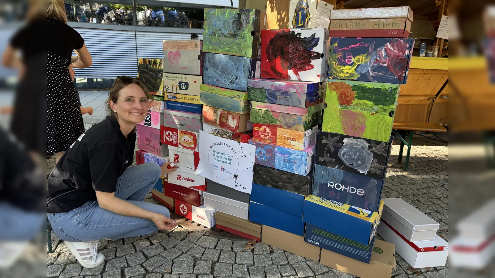 Miriam Sontheim vor den bemalten Schuhkartons. Sie symbolisieren Kinderrechte als Bausteine für die Demokratie.  (Foto: pst)