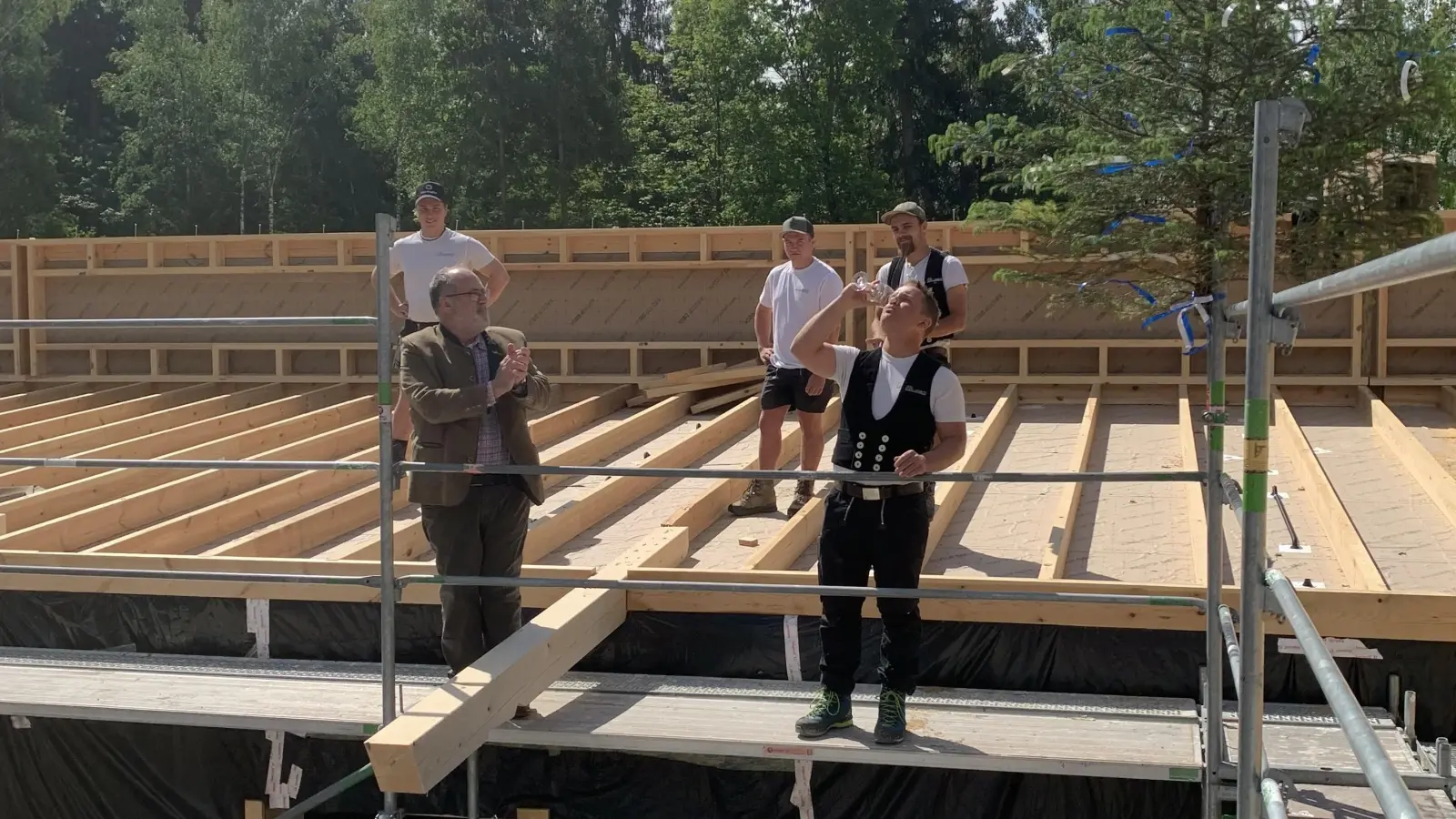Bürgermeister Dr. Stefan Straßmair (v.l.) und Zimmerer Georg Gruber (v.r.) trinken auf das Wohl des neuen Waldhorts und Kindergarten Outback beim Richtfest. (Foto: Gem. Hohenbrunn)