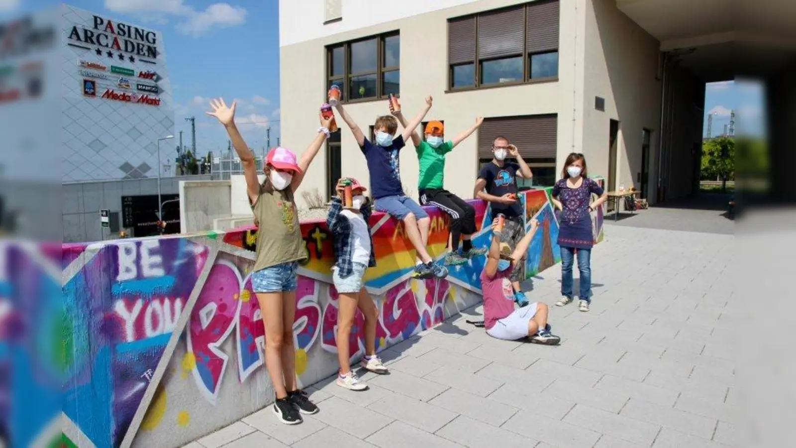 Geschafft! Dagmara Sosnowska vom Nachbarschaftstreff und der Künstler Benjamin Herzberg mit einigen der Kinder vor der fertigen Graffiti-Wand. (Foto: us)