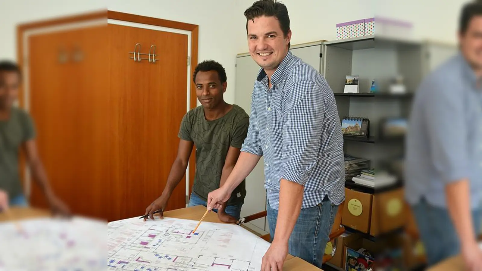 Rathausmitarbeiter Adrian Okrey (r.) studiert mit seinem Praktikanten Berhane Teklay einen Bauplan.	 (Foto: MO)