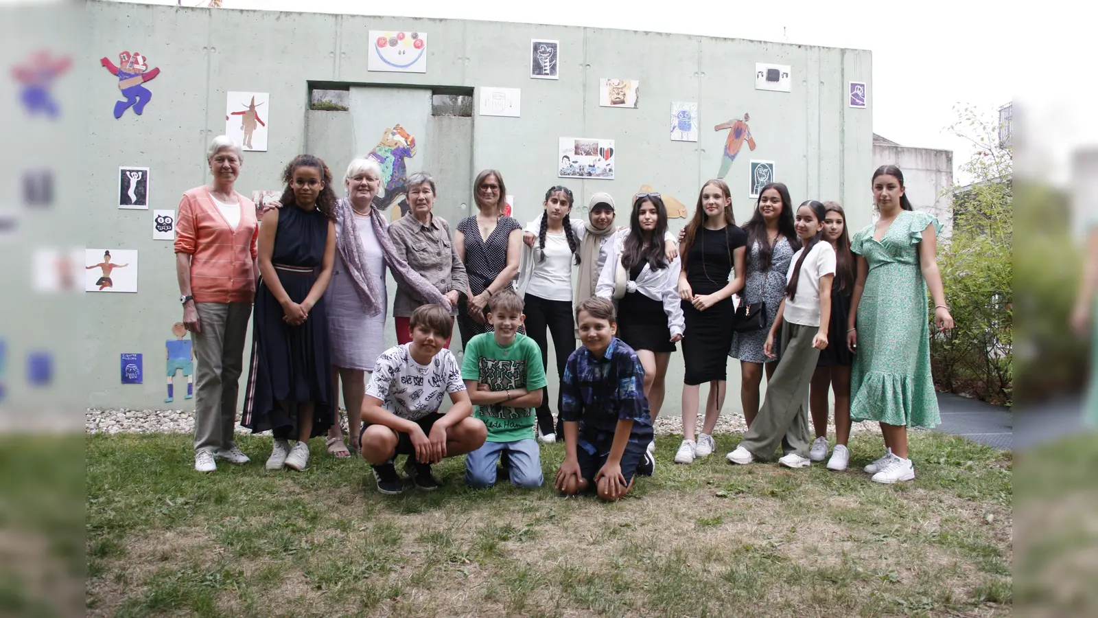 Die Seniorinnen und die Schüler mit ihrer Konrektorin Tanja Schäfer (hinten, Fünfte von links) freuen sich über ihre Kunstwerke, die an der Betonwand zu sehen sind. (Foto: job)