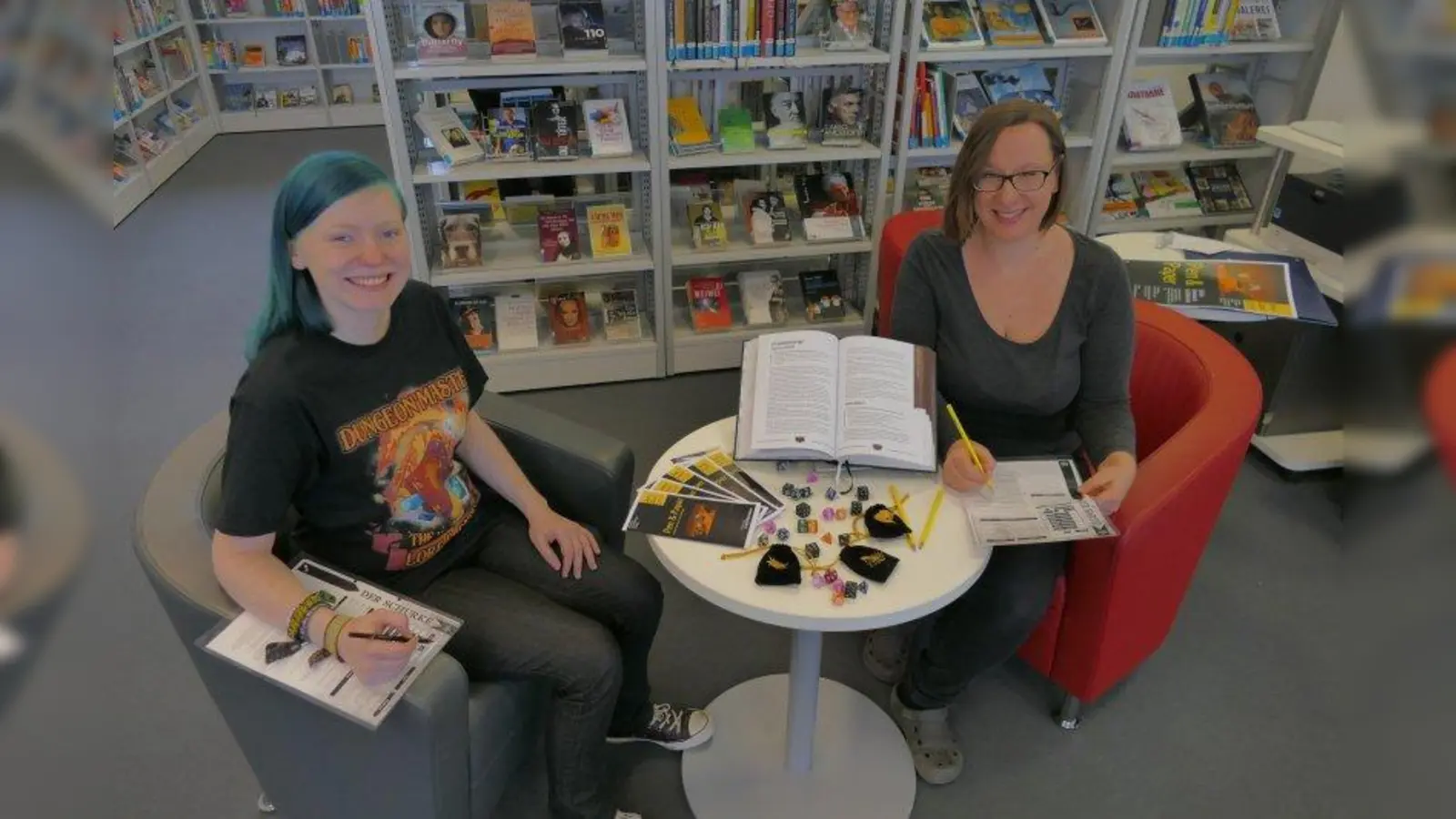 Melanie Ratjen (links) und Stefanie Klenk halten schon das Spielmaterial bereit: Ab 25. Januar können alle Interessierten beim Pen &amp; Paper-Rollenspiel zum Beispiel als Schurke, Heiler, Krieger oder Magier eine einzigartige Geschichte entstehen lassen. (Foto: ds)