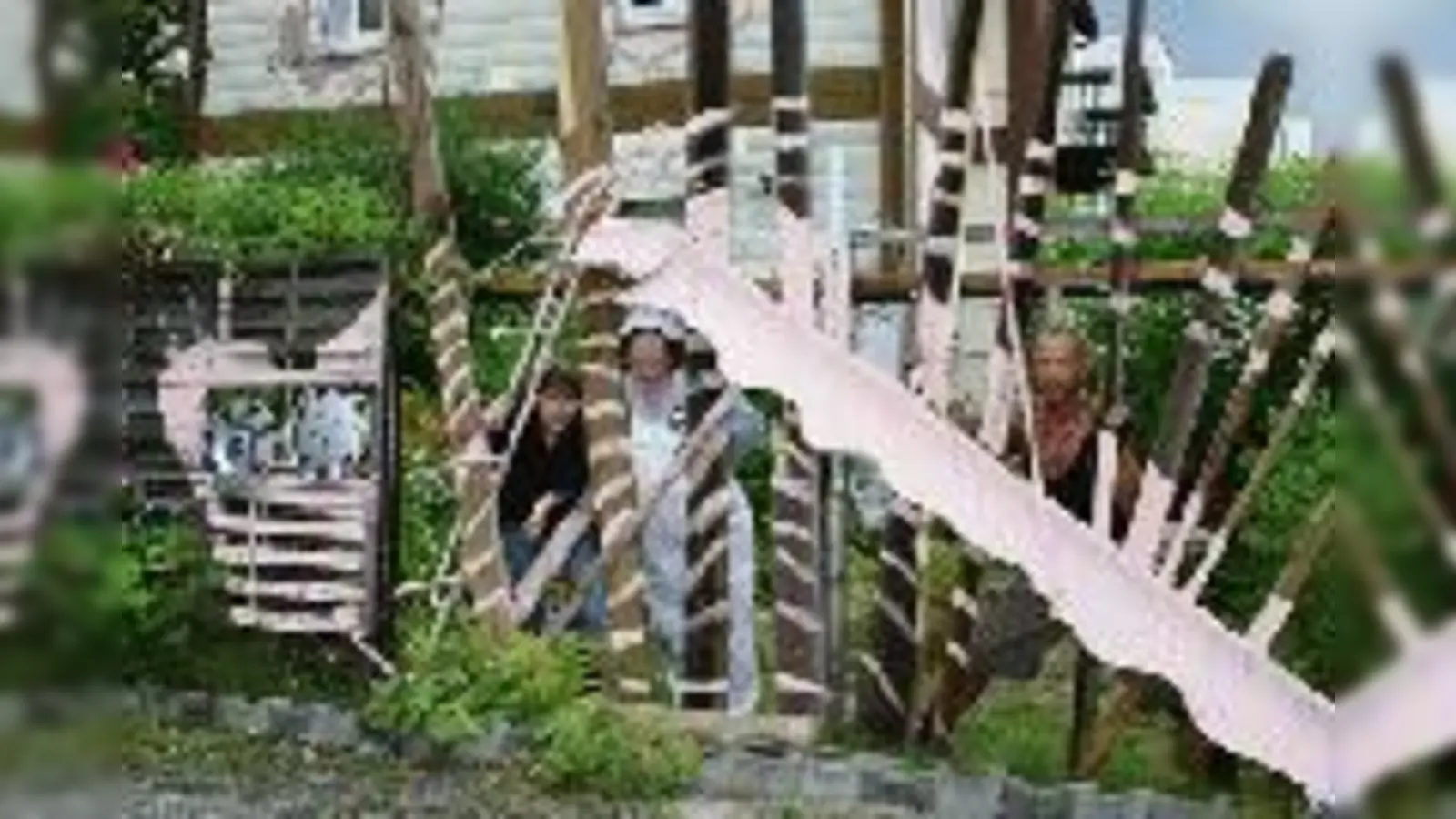 Die Künstler Silke Gottschalk, alias gottschalk*berlin, Felicitas Adler, alias ADLER A.F., und Franz Baron von Schönberg-Roth-Schönberg (v.l.) hinter dem rosaroten Moosacher Monster auf dem Grundstück in der Darmstädter Straße.  (Foto: wei)