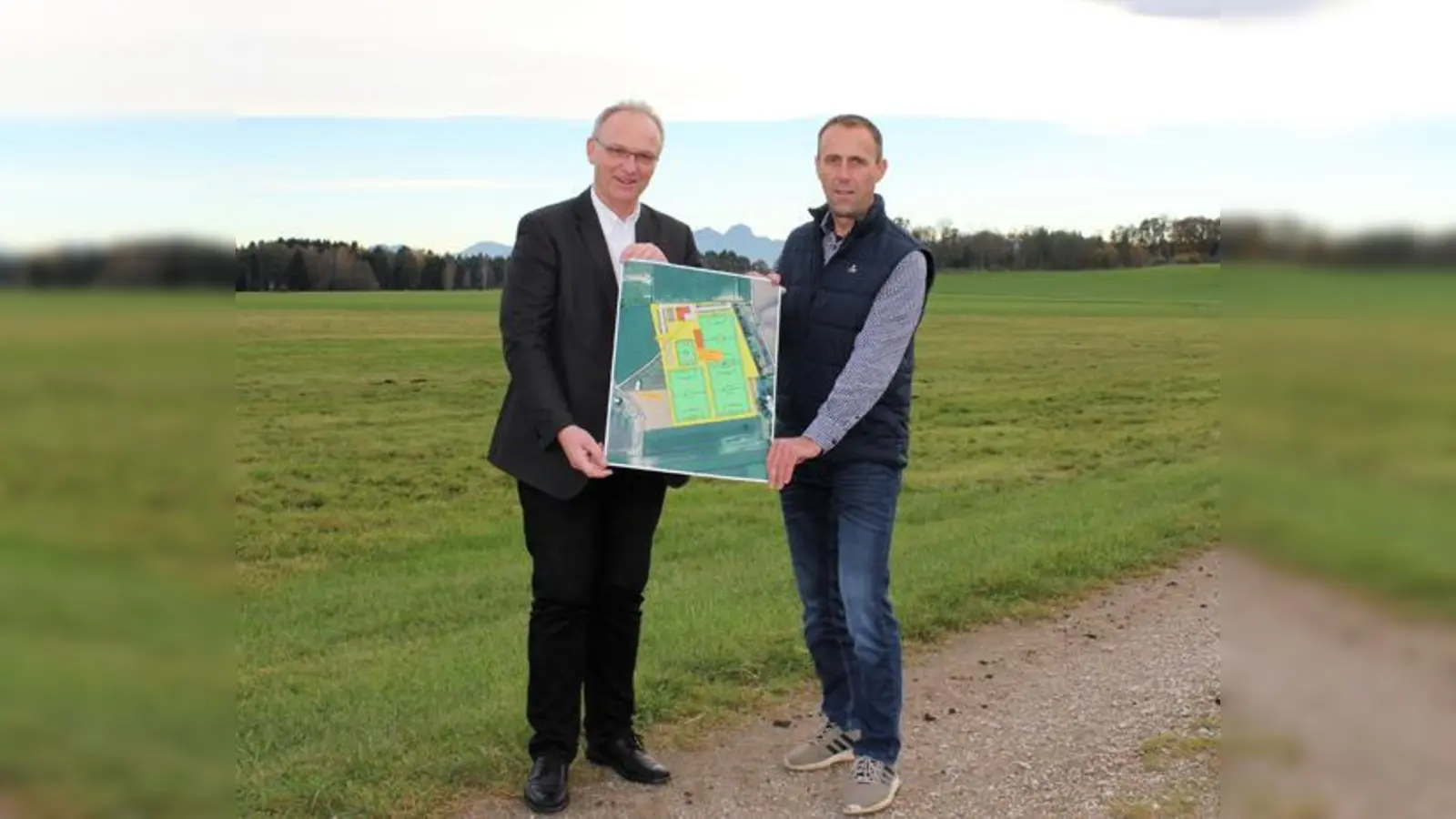 Bürgermeister Hans Fent (rechts) und Geschäftsleiter Wilfried Graupen mit einer Planskizze, wie das Sportgelände einmal angelegt sein könnte.  (Foto: Gemeinde Aßling)