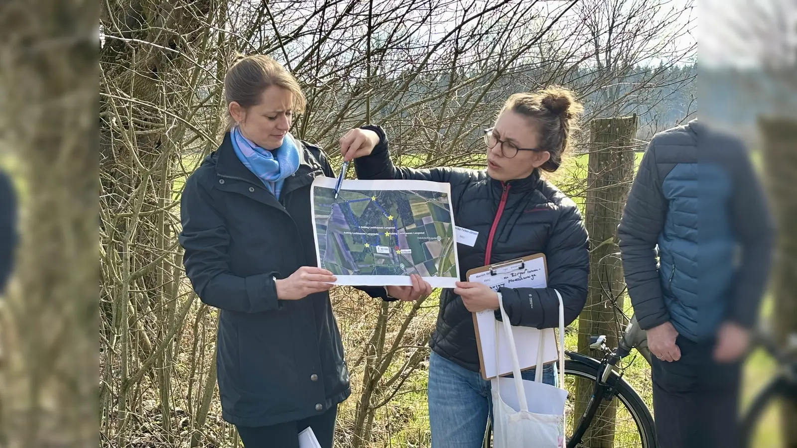 Marion Schmid und Veronika Felber-Jansen vom Referat für Klima- und Umweltschutz erklären die Vorhaben für die Aubinger Moosschwaige. Rund 20 Bürger kamen zum Ortstermin. (Foto: Ulrike Seiffert)