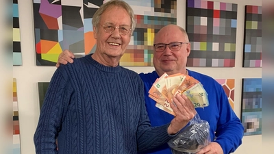 Schiedsrichter Manfred Trautmann (links) übergibt eine Spende in Höhe von 220 Euro an Jörg Göppert vom Verein „Klettham kommt zusammen“.  (Foto: Stadt Erding)