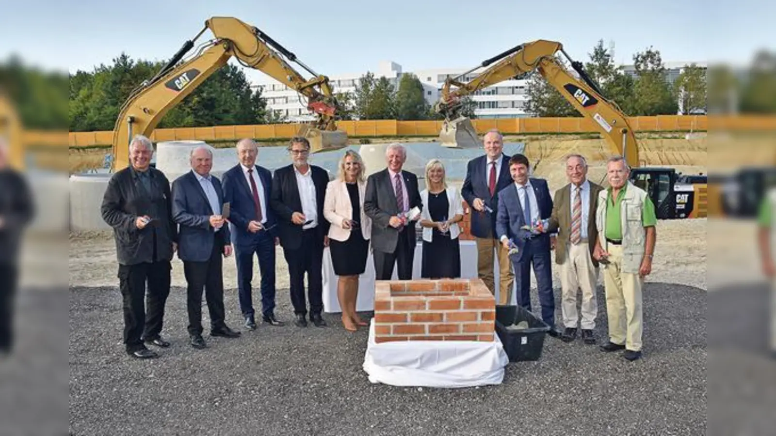 Wenn Politiker zur Kelle greifen: Unterföhrings erster Bürgermeister Andreas Kemmelmeyer (3. v. re.) legt zusammen mit Landrat Christoph Göbel (4. v. re.) und weiteren geladenen Gästen und Politikern den Grundstein für den Schulcampus.  (Foto: UFG/foe)