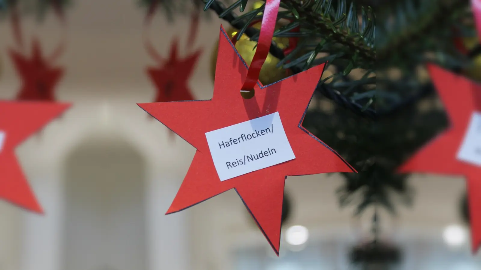 Am Weihnachtsbaum im Rathaus hängen Zettel mit Wünschen von Befürftigen. Die Geschenke einfach zusammen mit dem Stern wieder unter den Baum legen, dann werden sie verteilt.  (Foto: Gemeinde Eching)