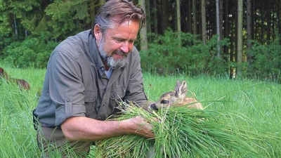 Thomas Schreder bringt ein Rehkitz in Sicherheit. 	 (Foto: VA)