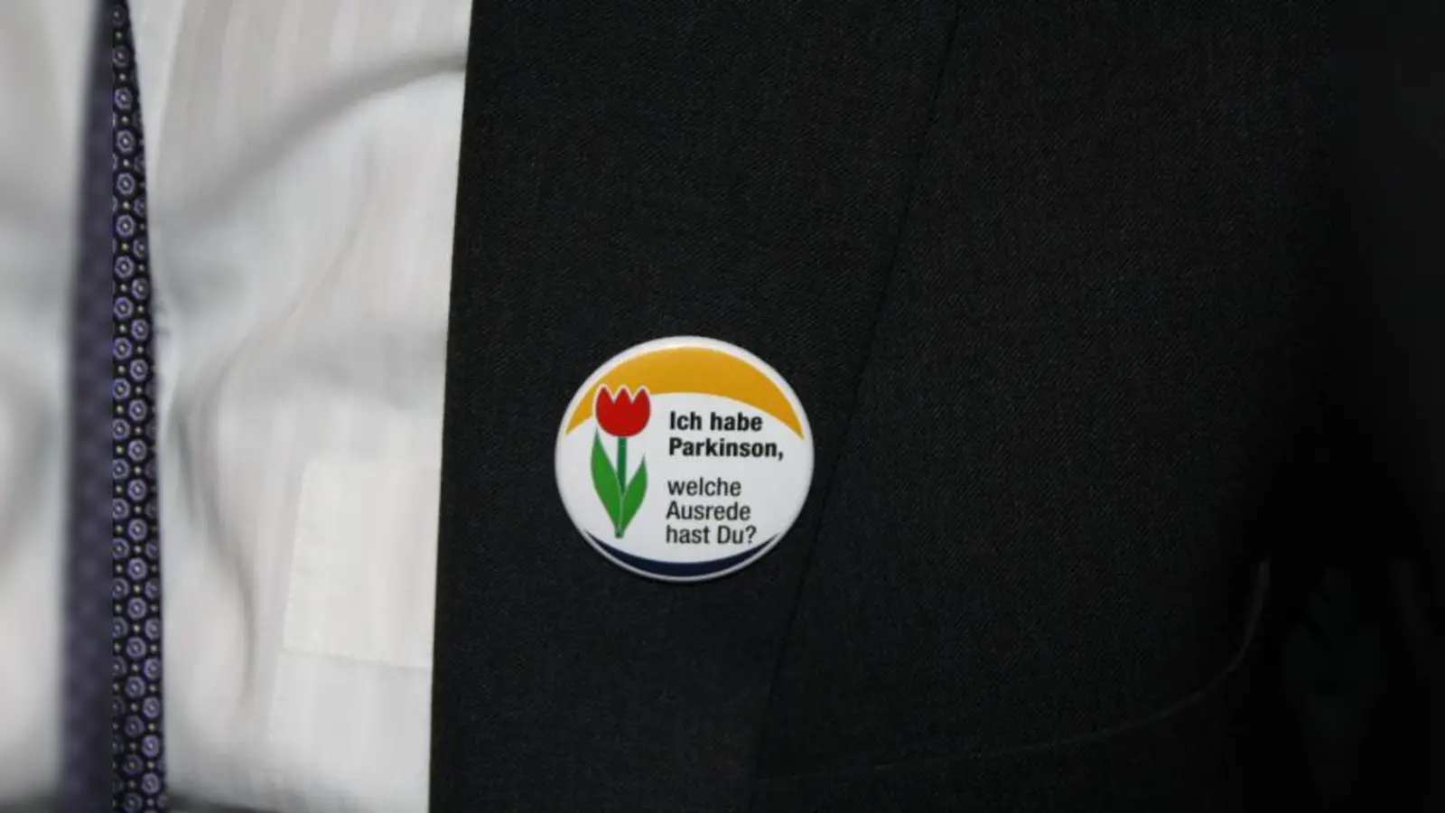 Parkinson hat weltweit ein einheitliches Symbol - eine rote Tulpe. Gerhard Schumann trägt den Anstecker immer an seiner Kleidung. (Foto: E.S.)
