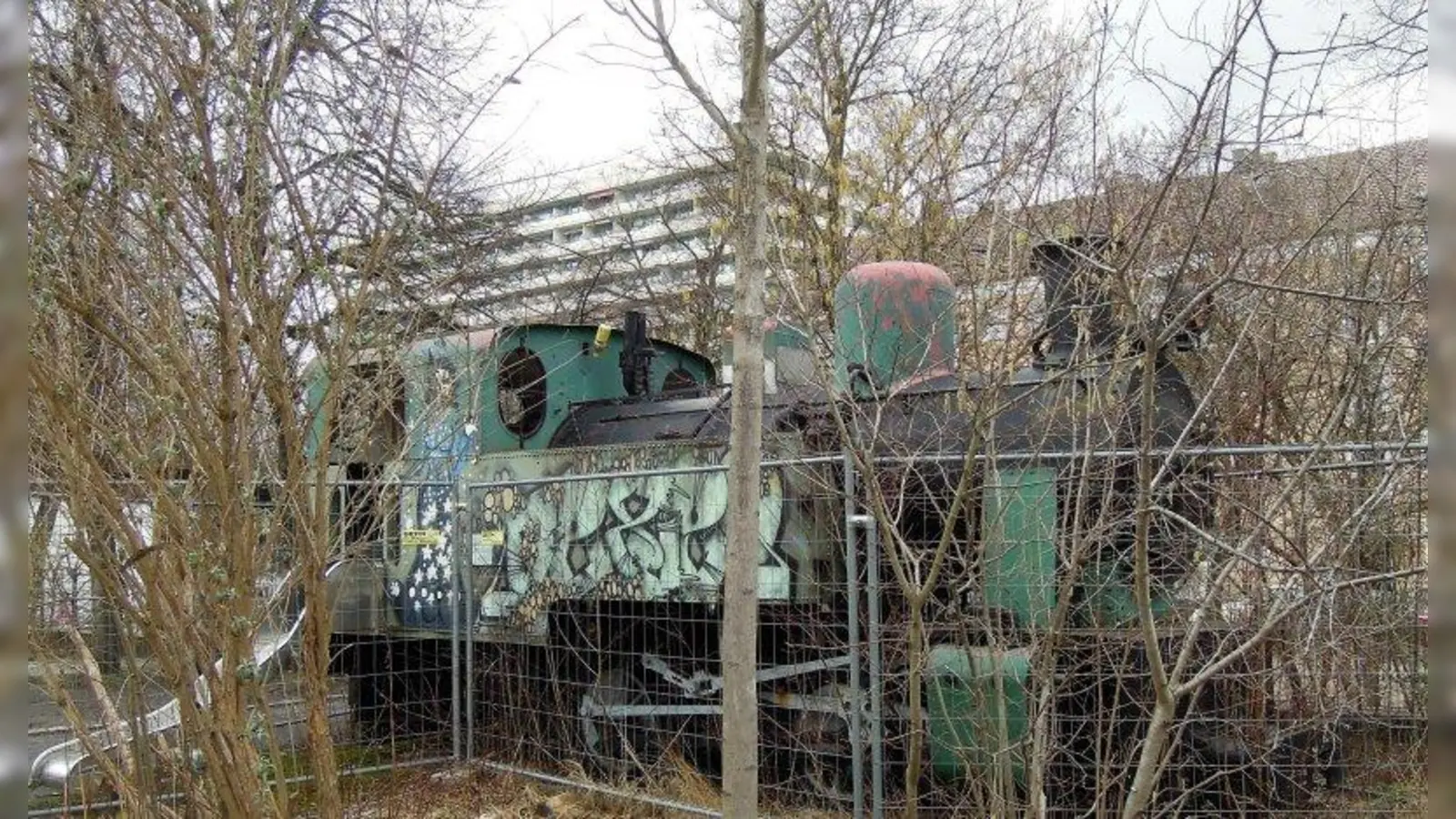 Damit sich keiner an der alten Lok, die auf dem Schulhof der Konrad-Celtis-Schule steht, verletzt, ist sie bisher mit einem Bauzaun eingefasst. Vielleicht kann sie auf dem Luise-Kiesselbach-Platz einmal als Denkmal erstrahlen. (Foto: jb)