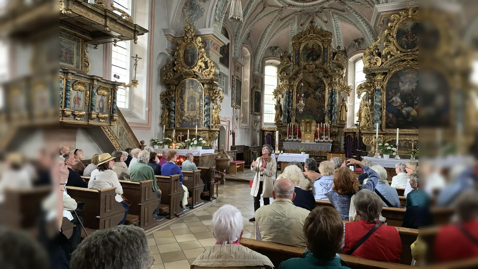 In Sachrang war die Kirche St. Michael das kunsthistorische Ziel - Carmen Reinstädler erklärte das aufwändige Bildprogramm. (Foto: Heike Kronseder)