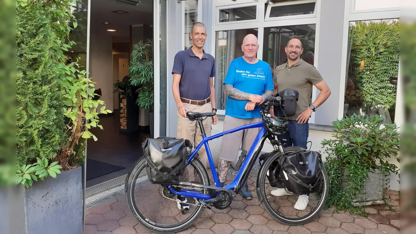 Oliver Trelenberg (m.) radelt für den guten Zweck und machte kürzlich Station in Weilheim. Hier begrüßten ihn Radverkehrsbeauftragter Stefan Frenzl (l.) und Benedikt Borgmann (Hotel Vollmann). (Foto: Stadt Weilheim)