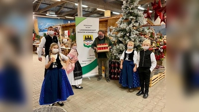 Kerzenübergabe: Carolina und Victoria von der Banater Kindertanzgruppe mit ihrem Leiter Harald Schlapansky (links),Thomas Gebert vom Daglfinger Blumenhof (mitte) und das Geschwisterpaar Hanna und Jonas (rechts). (Foto: privat)