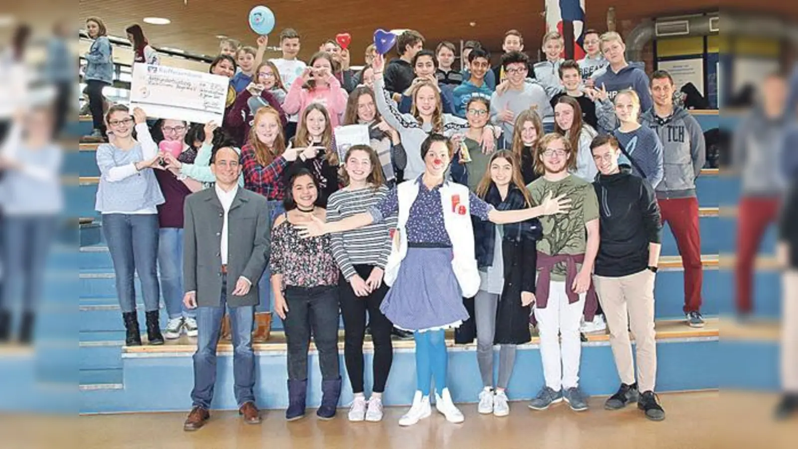 Die Theaterklasse 7d und Vertreter der Schülermitverwaltung mit KlinikClownin Fiderallala (vorne Mitte) und Direktor Andreas Hautmann (links vorne).	 (Foto: Carl-Orff-Gymnasium)