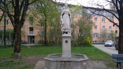 Der Auia-Brunnen in der Lilienstraße zeigt eine Allegorie die Vorstadt Au. Sehenswerte Denkmäler sind auch der Schmederersteg und die Grützner-Villa. (Foto: bs, Rufus46/CC BY-SA 3.0)