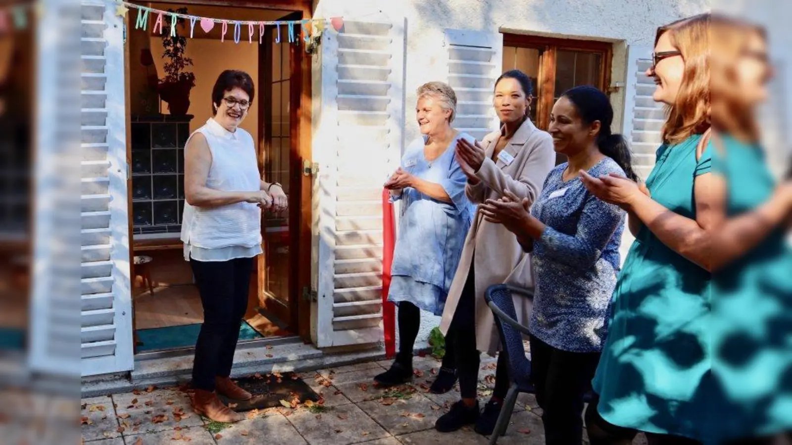 „Mary Poppins” in Gauting: Bürgermeisterin Brigitte Kössinger (links) schnitt symbolisch das Einweihungsband durch und schenkte der Einrichtung zwei Brombeersträucher für den Garten. Daneben (von links) die Leiterinnen der neuen Einrichtung Erika Jellen, Pearl Sullivan und Glaciene Schmitz sowie aus der Gemeindeverwaltung Michaela Kammermeier. (Foto: Erika Jellen)