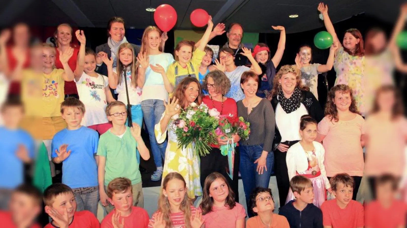 Großes Finale des Musicals „1.000 Farben hat die Welt” in der Aula der Grundschule Martinsried. Mit Blumen: Schulleiterin Margit Baran-Lander, rechts daneben Waltraut Bachmann-Zeune sowie Tanja Gilger und Carolin Bals-Junker vom Elternbeirat. In der letzten Reihe stehend Gela Schniewind und Thaomas Schaffert. (Foto: us)