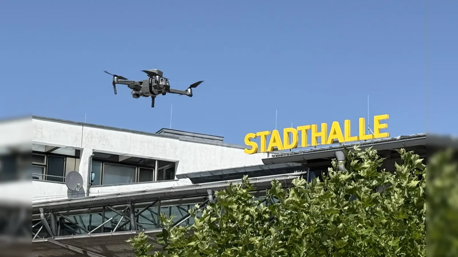 Rasch propellert sich die Drohne vor der Stadthalle in die Höhe (Foto: pst)