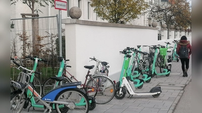 E-Scooter blockieren diese Feuerwehrzufahrt (links) an der Moosacher Straße und lassen für Passanten (rechts) kaum Platz auf dem Gehweg. Der Voi-Sprecher meint dazu: „Die Diskussion kommt zur falschen Zeit”. (Foto: job)