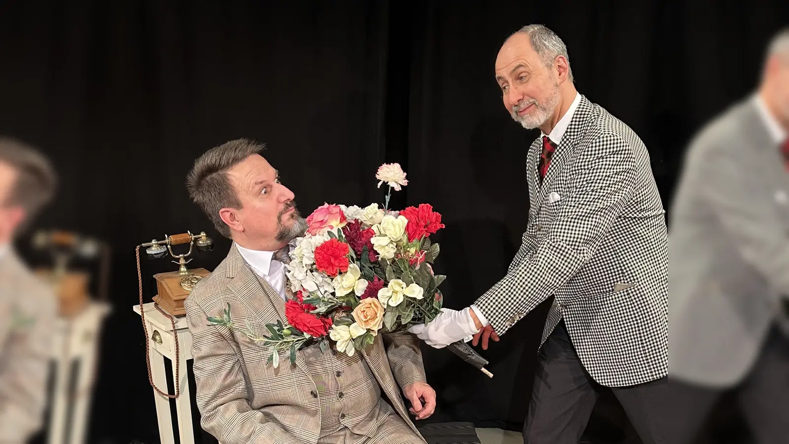 Albert Leroi überrascht Pierre Barnier, seinen vermeintlichen Schwiegervater in spe, mit einem Blumenstrauß. (Foto: Theater in der Au)