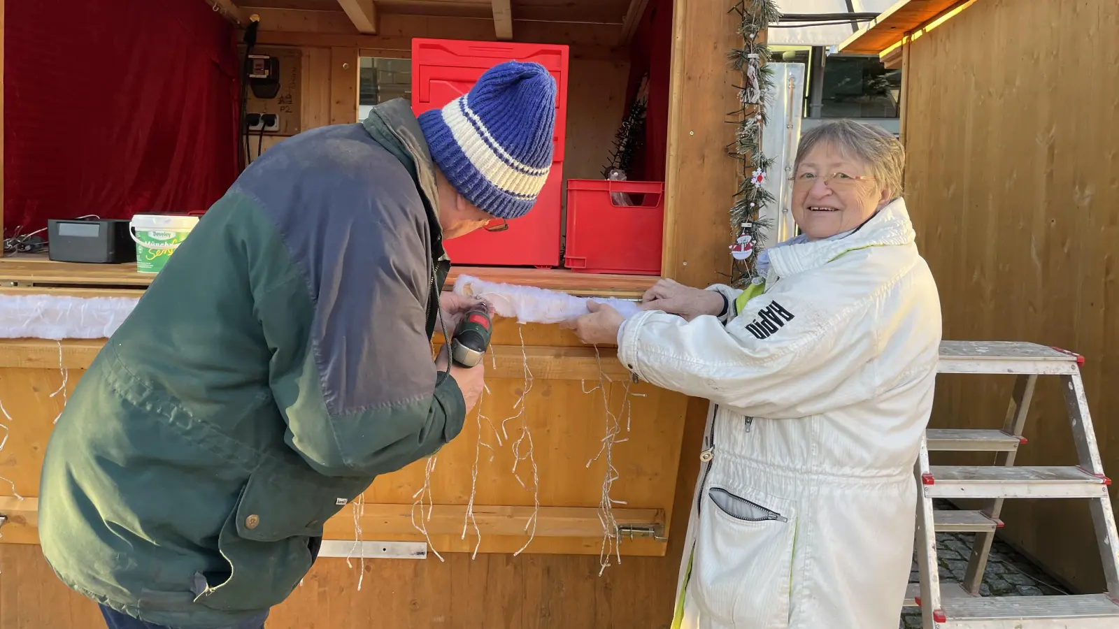 Elisabeth Kardel bereitet mit ihrem Mann ihren Stand mit Tonwaren für die Eröffnung des Christkindlmarkts vor. (Foto: pst)