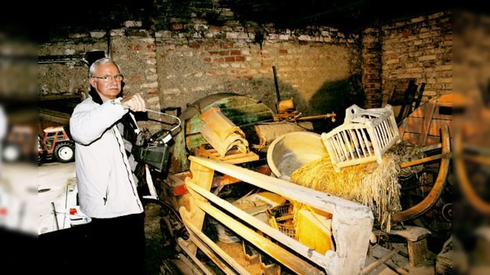 Helmut Keßler vor den Exponaten des Kulturhistorischen Vereins. Ein Teil davon wird derzeit auf einem Bauernhof am Feldmochinger See gelagert. 	 (Foto: J. Stark)