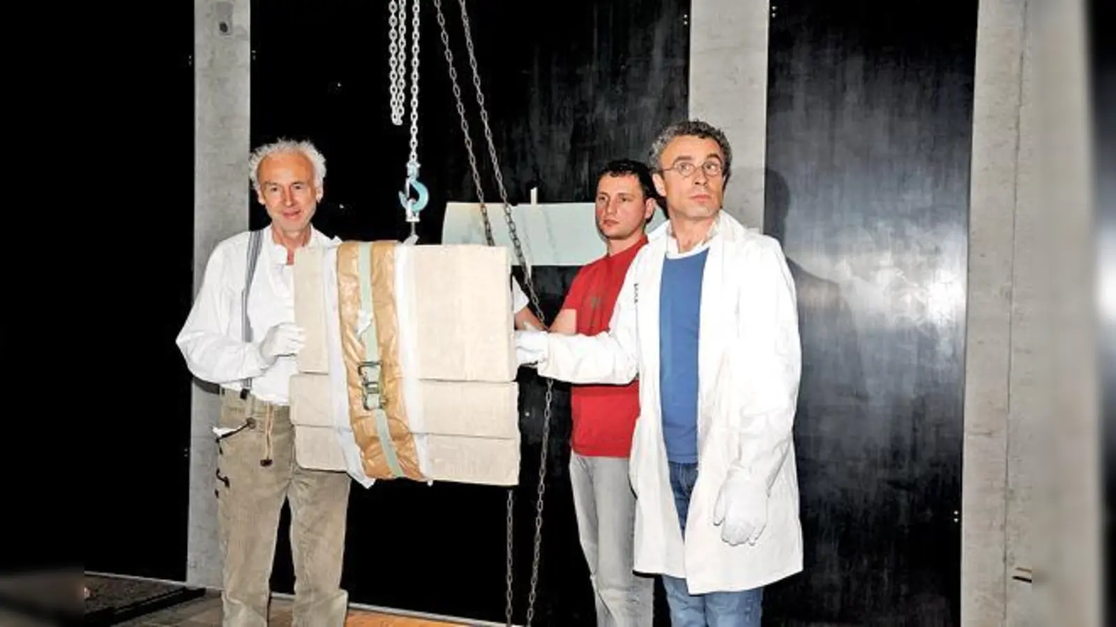 Restaurator Michael Pfanner (links) und Kollegen hängen die ersten Objekte im neuen Museum auf, hier eine sogenannte Scheintür zum Jenseits.	 (Foto: Museum)