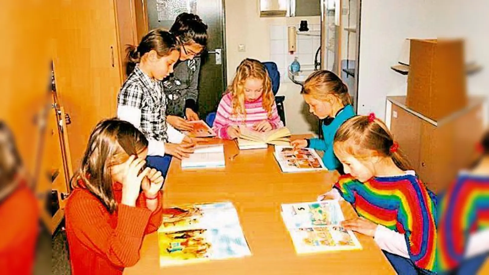 Schüler der 6a helfen beim Bibliotheksbetrieb und bleiben schon mal beim Schmökern hängen. (Foto: Privat)