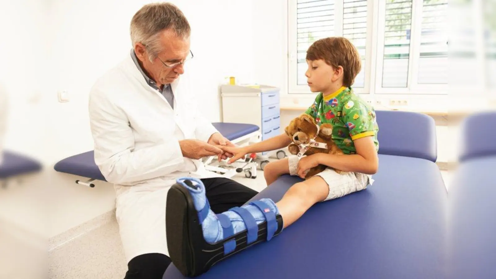 Prof. Dr. Bernhard Heimkes mit einem jungen Patienten in der Sprechstunde. (Foto: Simon Katzer)