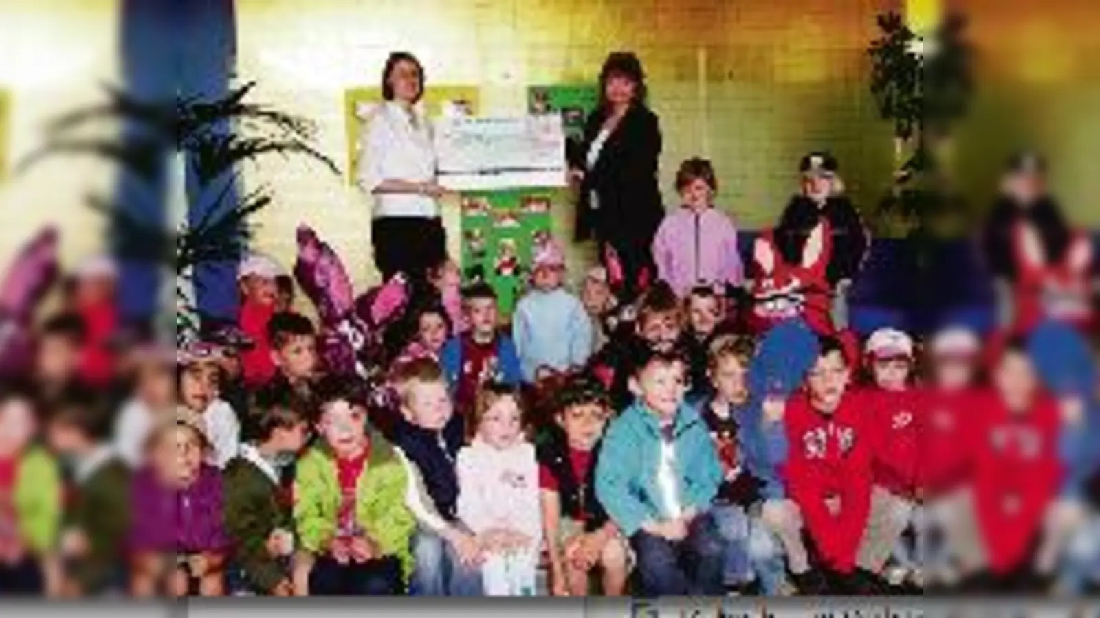 Redlich verdiente Künstlergage: Die Leiterin des Kindergartens St. Jakob, Angelika Schuhnicht (l.), und ihre kleinen Talente holten sich bei M. Raith (r.) von der Feldkirchener Raiffeisenbank ab.  (Foto: VA)