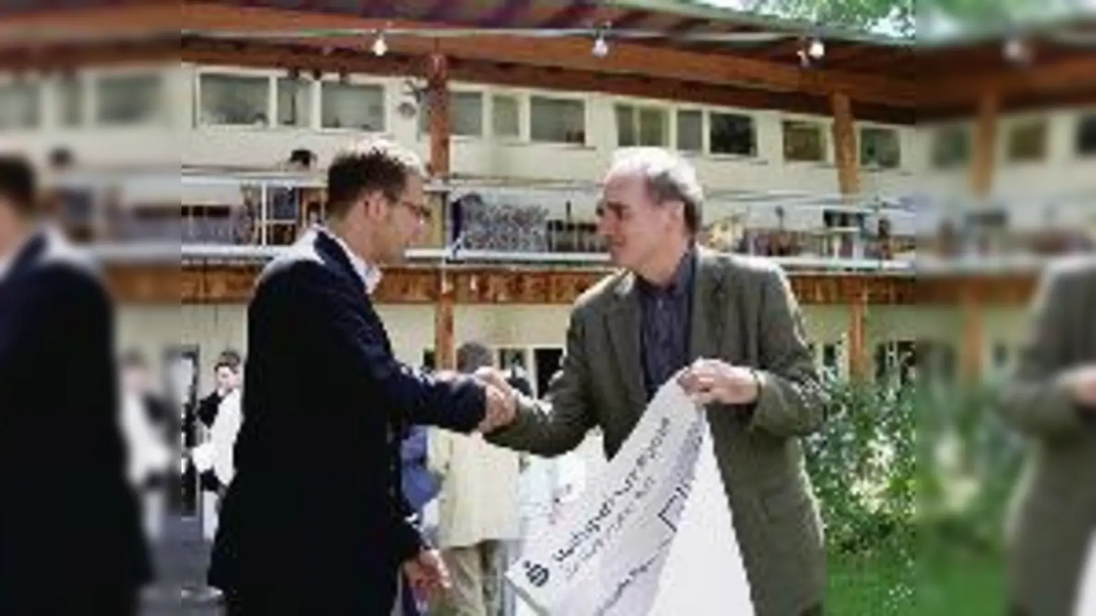 Früher setzte man sich am Maßmannplatz für Demokratie ein, heute fürs Klima: Christoph Schützenhofer (li.) und Umweltreferent Joachim Lorenz beglückwünschen sich zum Start der umweltfreundlichen Sanierung des Wohnheims. 	 (Foto: mh)