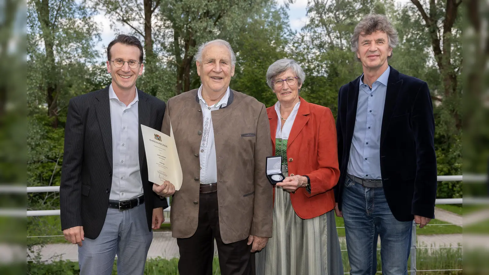 Stefan Frey (links) und Steffen Kirchner überreichten Leonhard Lenker in Begleitung seiner Ehefrau Adele Lenker die Urkunde und die Medaille für 50 Jahre Ehrenamtmals Feldgeschworener. (Foto: Landratsamt Starnberg)