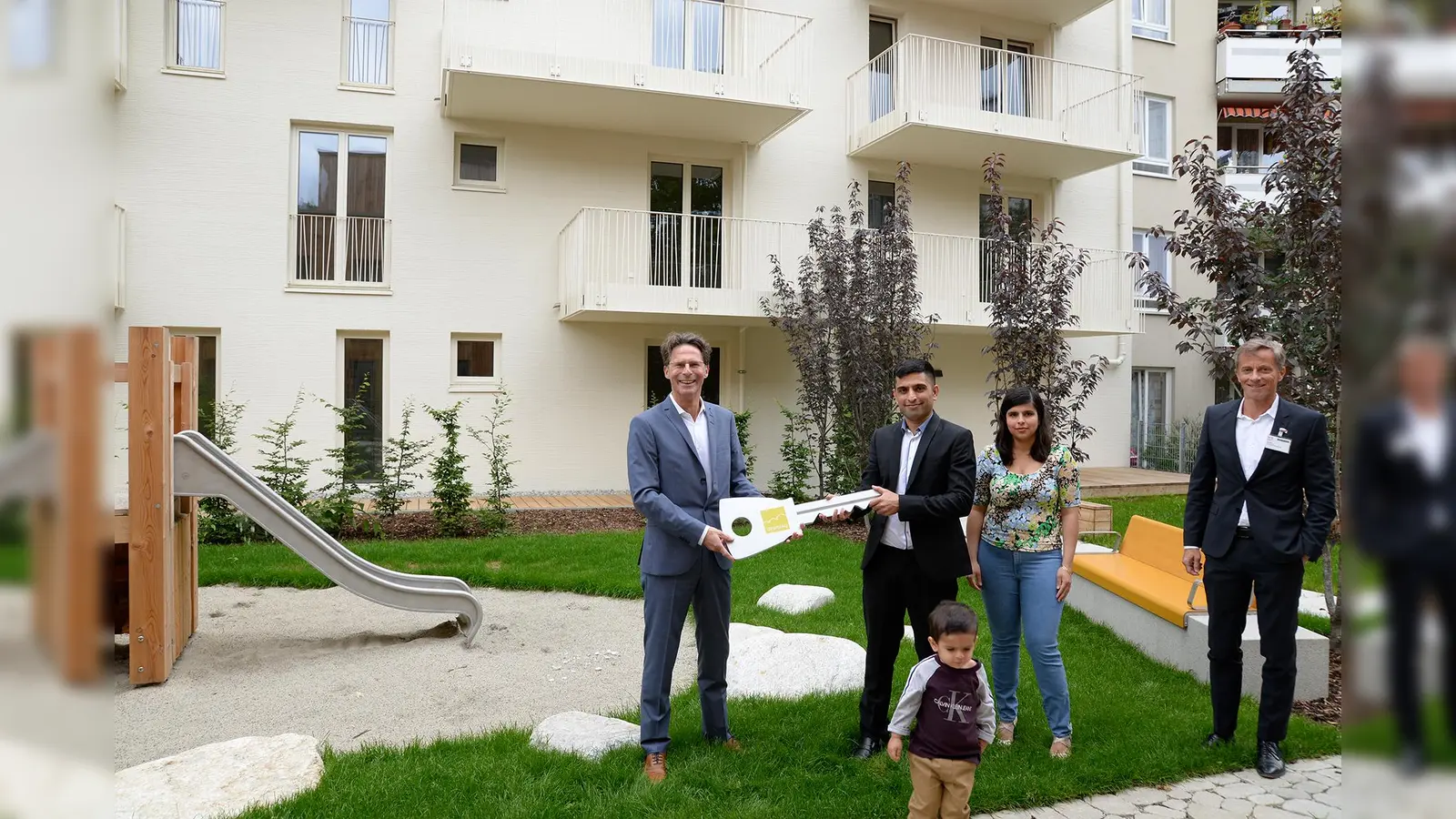 Klaus-Michael Dengler (links), Familie Nori und Axel Fischer bei der Schlüsselübergabe. (Foto: Gewofag)