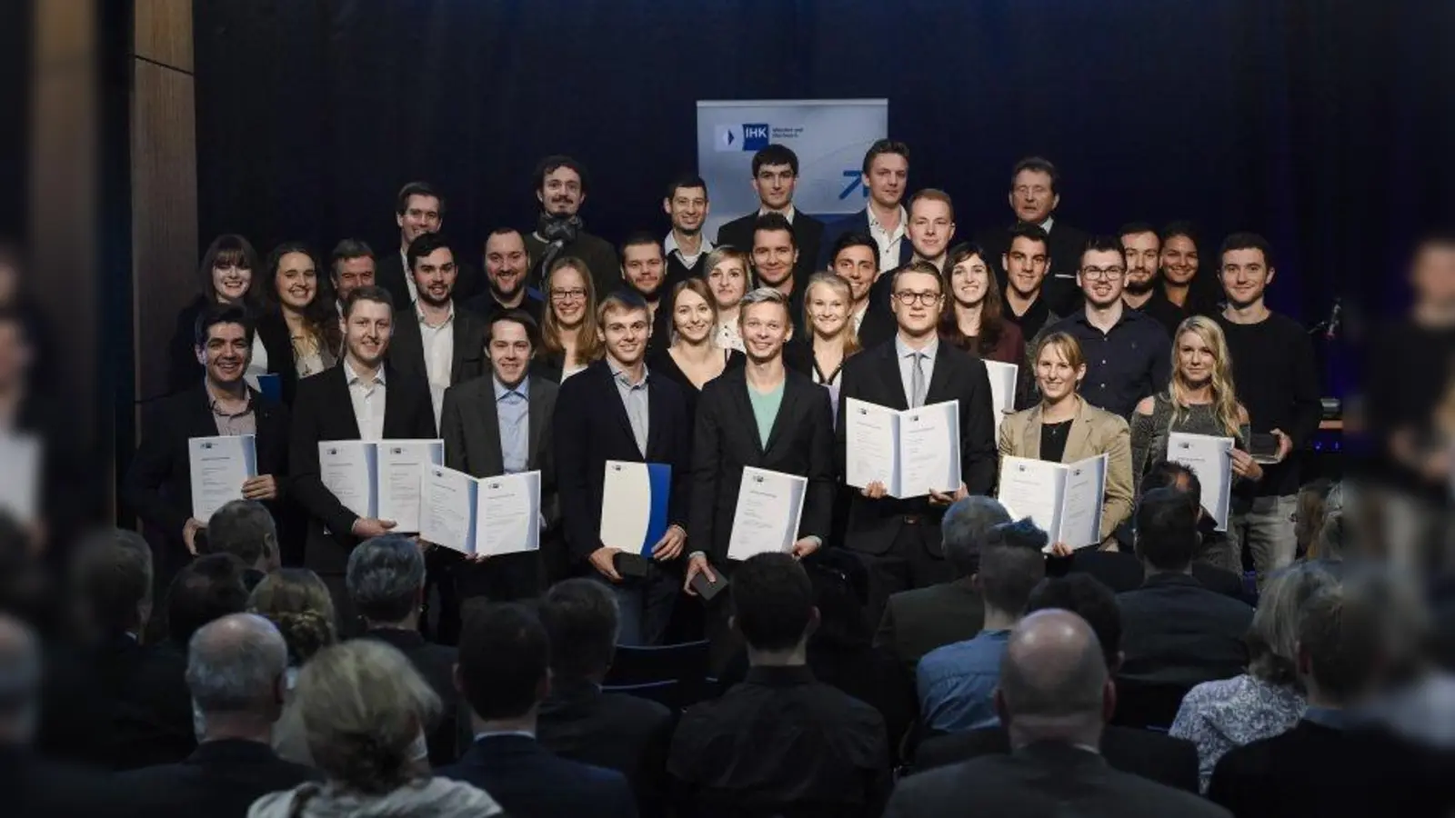 IHK-Präsident Eberhard Sasse (re.) und Thomas Kürn (li.), IHK-Bereichsleiter Berufsbildung, beglückwünschen die Besten von Münchner Ausbildungsunternehmen. (Foto: Andreas Gebert/ IHK München)