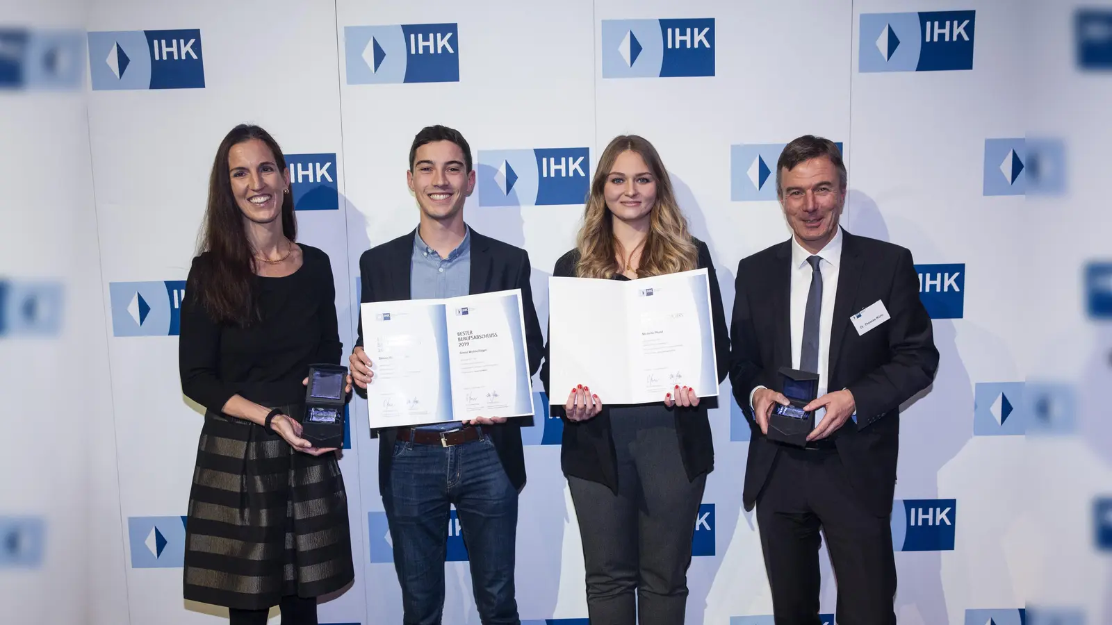 Kathrin Wickenhäuser-Egger (li.) und Dr. Thomas Kürn (re.), beglückwünschen die Top-Azubis aus dem Landkreis Erding: Michelle Pfund und Simon Wohlschläger. (Foto: © IHK für München und Oberbayern / Goran Gajanin)