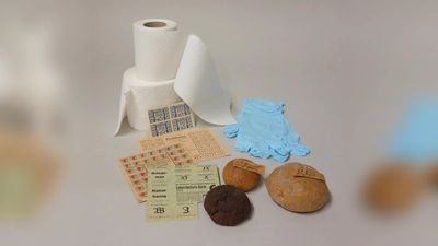 Kriegssemmeln und Lebensmittelkarten aus den Weltkriegen sowie begehrte Ware in der Corona-Krise: Toilettenpapier und Schutzhandschuhe.  (Foto: Museum Erding)