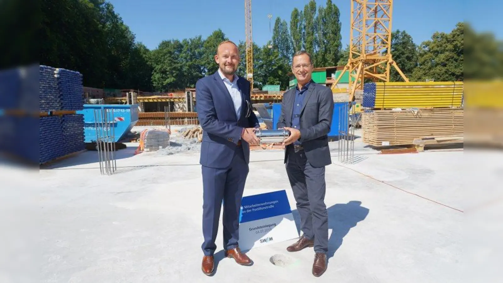 Bernhard Boeck (links), Leiter SWM-Immobilien, und Werner Albrecht, SWM-Geschäftsführer Personal, Immobilien, Bäder versenkten bei der Grundsteinlegung für den Werkswohnungsbau Postillonstraße die Zeitkapsel im Boden. (Foto: SWM/Vauel)