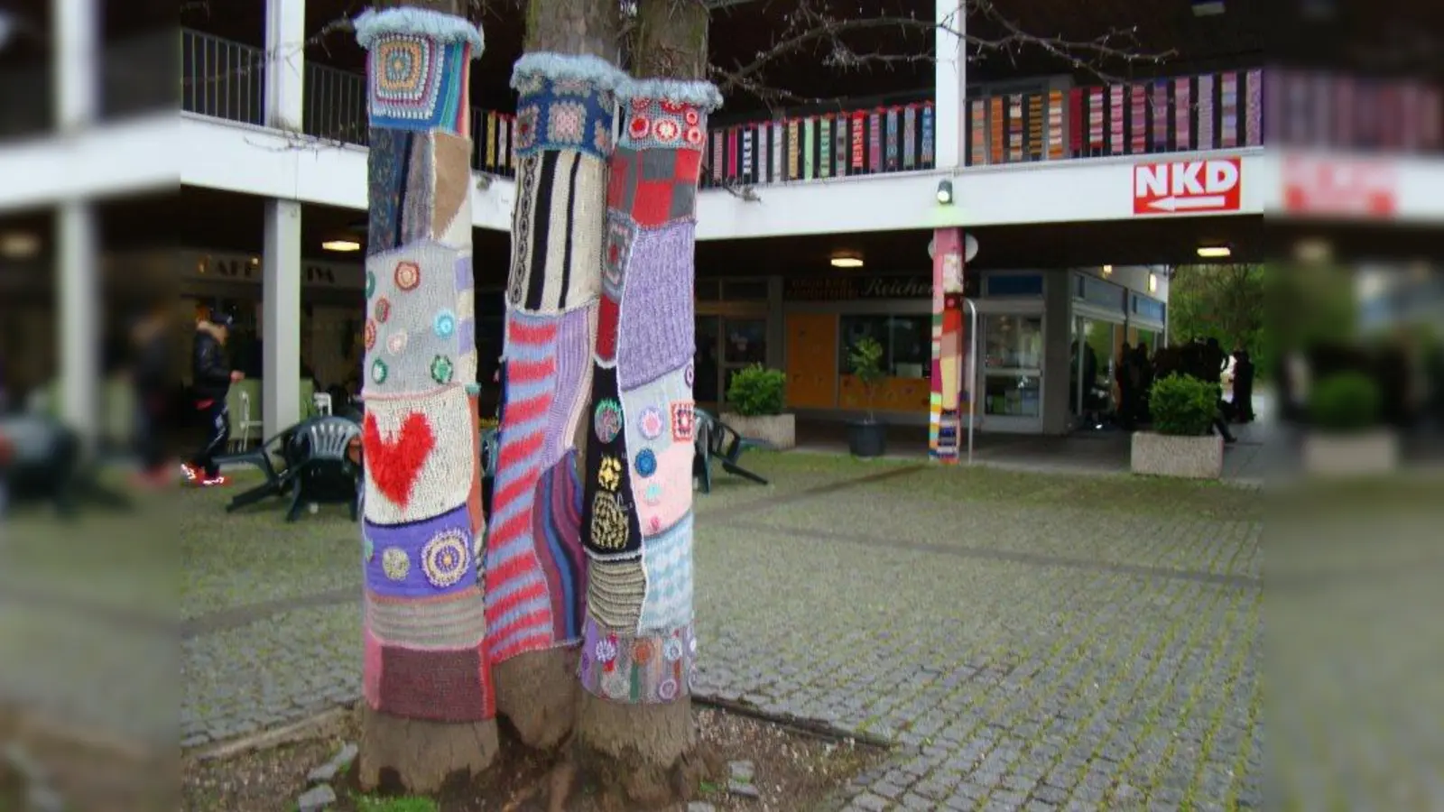 Das kann auch alles Selbstgestrickte nicht darüber hinweg helfen: das Geschäftszentrum in der Wiesentfelser Straße ist in die Jahre gekommen. (Foto: pst)